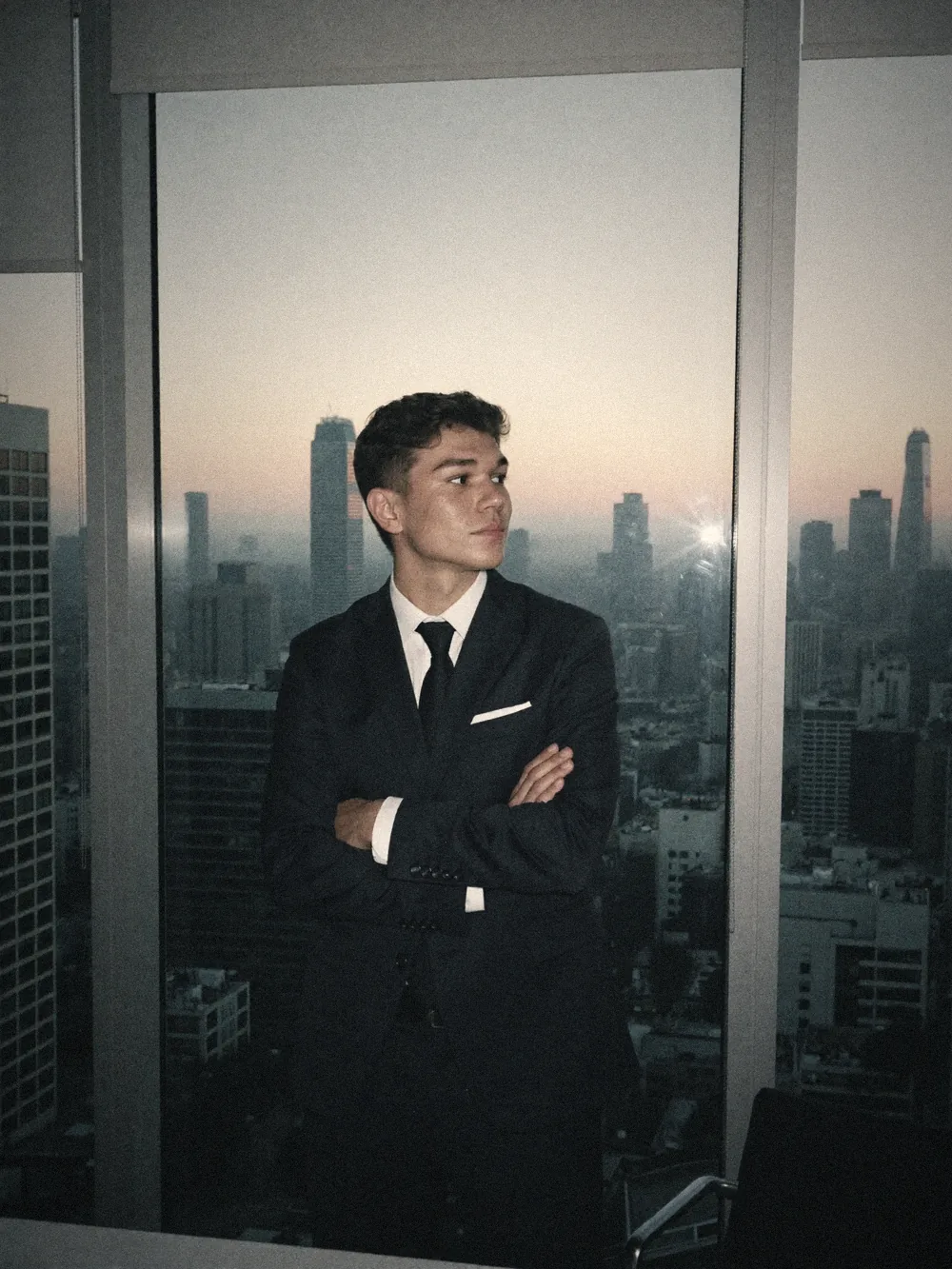 Marcel im Anzug vor einer Skyline