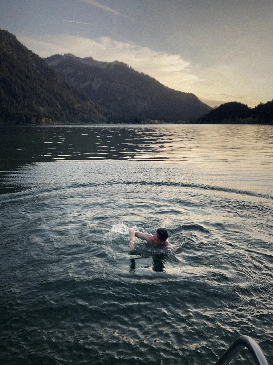 Marcel krault im Bergsee bei Sonnenuntergang
